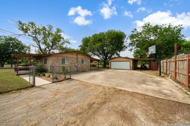 11301 Ford, Adkins, TX 78101 - view of home's exterior with driveway, an outbuilding, and a garage