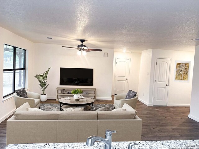 185 Quail Valley Dr, Bandera, TX 78003 - living room with a ceiling fan, baseboards, dark wood-style flooring, and a textured ceiling