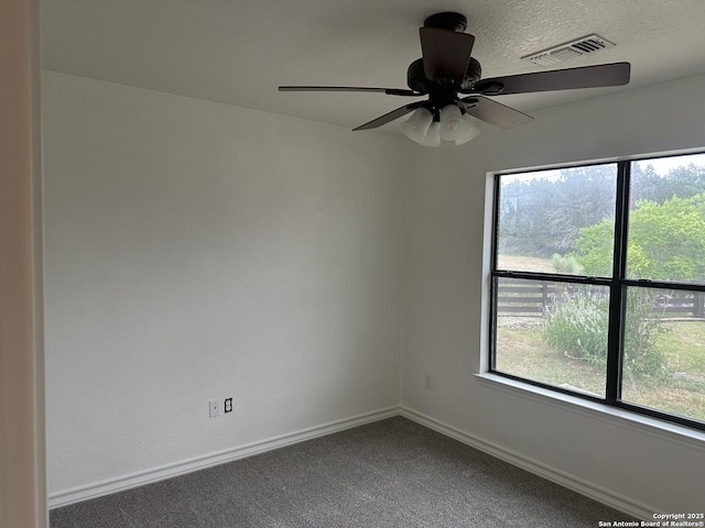 185 Quail Valley Dr, Bandera, TX 78003 - empty room with healthy amount of natural light, carpet flooring, baseboards, ceiling fan, and a textured ceiling