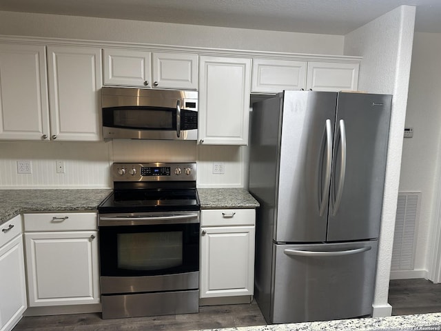 185 Quail Valley Dr, Bandera, TX 78003 - kitchen with appliances with stainless steel finishes, white cabinets, and dark wood-style flooring