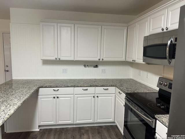 185 Quail Valley Dr, Bandera, TX 78003 - kitchen with stainless steel appliances, white cabinetry, dark wood-style floors, and dark stone countertops
