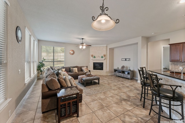 12234 Prince Solms, San Antonio, TX 78253 - living area with light tile patterned floors, a ceiling fan, a fireplace, and baseboards