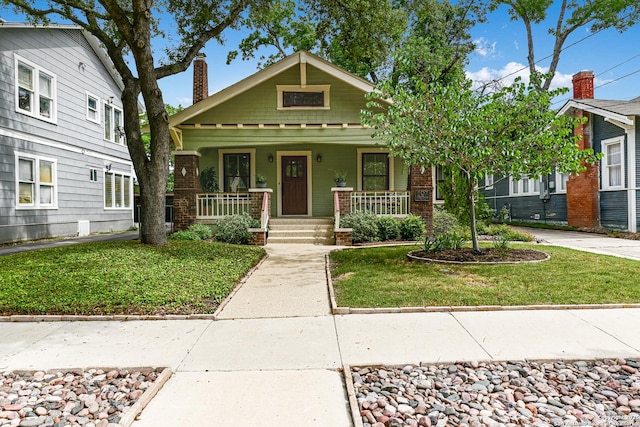 207 Queen Anne, San Antonio, TX 78209 - view of front of property with a chimney, a front lawn, a porch, and brick siding