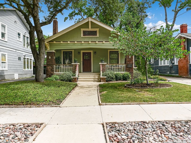 207 Queen Anne, San Antonio, TX 78209 - view of front of home featuring a chimney, a front lawn, a porch, and brick siding