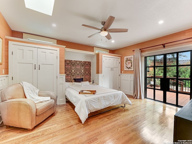 207 Queen Anne, San Antonio, TX 78209 - bedroom featuring access to exterior, light wood finished floors, wainscoting, a wall mounted air conditioner, and a skylight