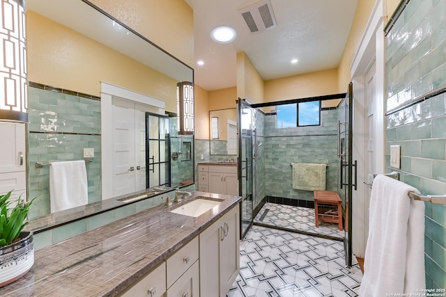 207 Queen Anne, San Antonio, TX 78209 - bathroom with vanity, a shower stall, tile walls, tile patterned floors, and recessed lighting