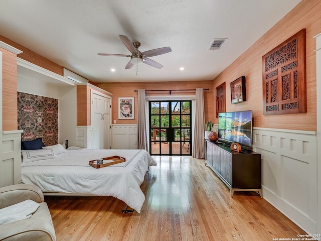 207 Queen Anne, San Antonio, TX 78209 - bedroom featuring access to exterior, light wood-style floors, a wainscoted wall, recessed lighting, and a decorative wall