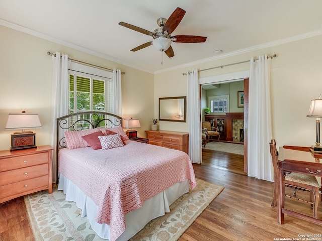 207 Queen Anne, San Antonio, TX 78209 - bedroom featuring wood finished floors, crown molding, a stone fireplace, and ceiling fan
