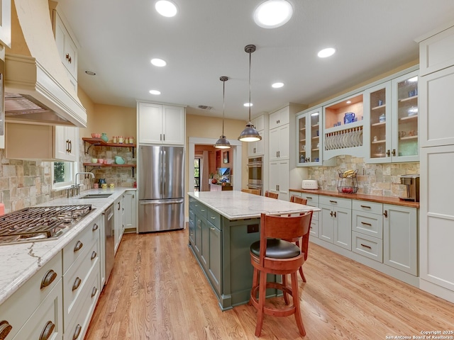 207 Queen Anne, San Antonio, TX 78209 - kitchen featuring appliances with stainless steel finishes, open shelves, a sink, custom exhaust hood, and tasteful backsplash