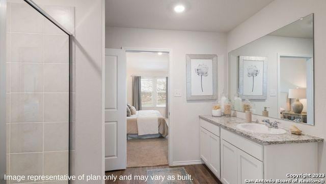 7222 Salado Creek Pkwy, San Antonio, TX 78222 - ensuite bathroom featuring vanity, wood finished floors, and a tile shower