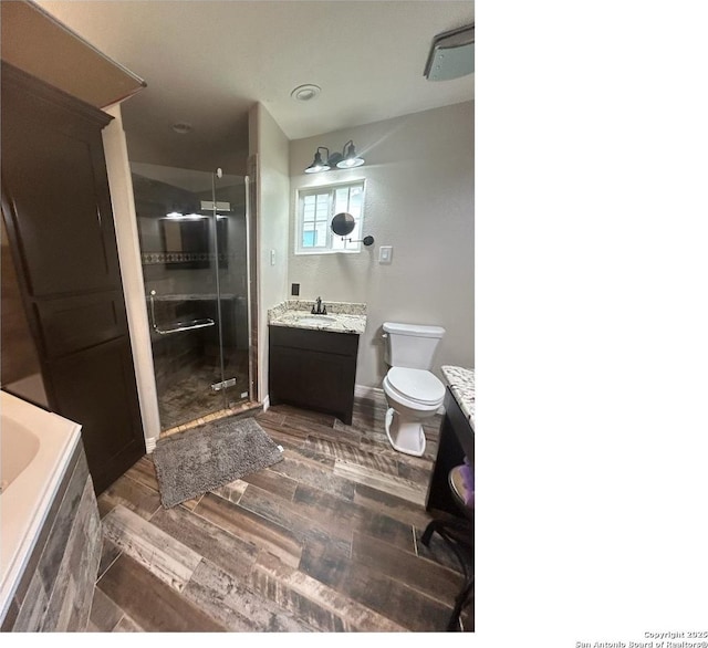 1924 Owens Ave, Groves, TX 77619 - bathroom with a stall shower, vanity, wood finished floors, toilet, and a tub to relax in