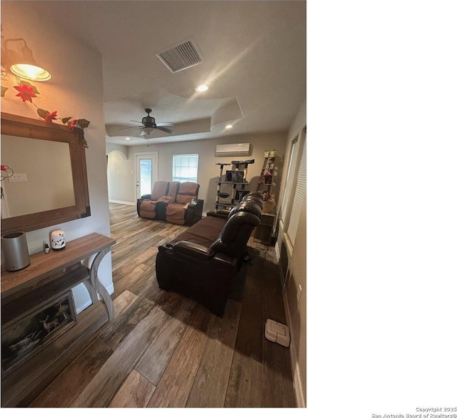 1924 Owens Ave, Groves, TX 77619 - living room with a wall unit AC, wood finished floors, a raised ceiling, recessed lighting, and ceiling fan