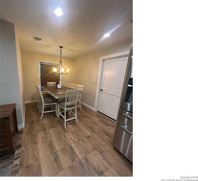 1924 Owens Ave, Groves, TX 77619 - dining area with a chandelier, baseboards, and a textured ceiling