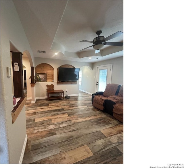 1924 Owens Ave, Groves, TX 77619 - living room with arched walkways, a tray ceiling, ceiling fan, baseboards, and recessed lighting