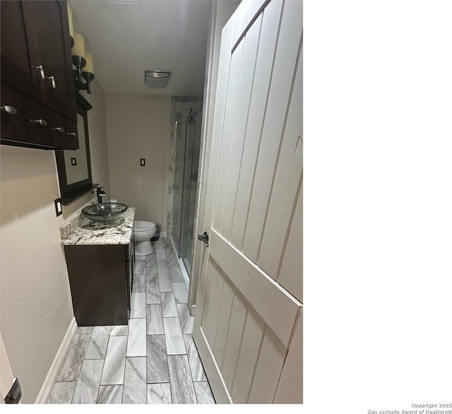 1924 Owens Ave, Groves, TX 77619 - full bathroom with toilet, a stall shower, vanity, and baseboards