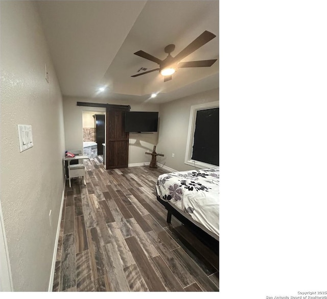 1924 Owens Ave, Groves, TX 77619 - bedroom with a barn door, dark wood finished floors, a textured wall, baseboards, and a ceiling fan