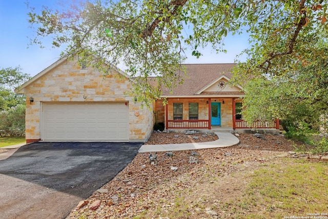 1831 Birch Ln, Fischer, TX 78623 - view of front of home with a porch, asphalt driveway, an attached garage, stone siding, and a shingled roof