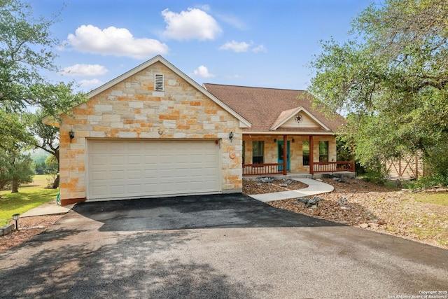 1831 Birch Ln, Fischer, TX 78623 - view of front of house featuring stone siding, driveway, covered porch, a garage, and a shingled roof