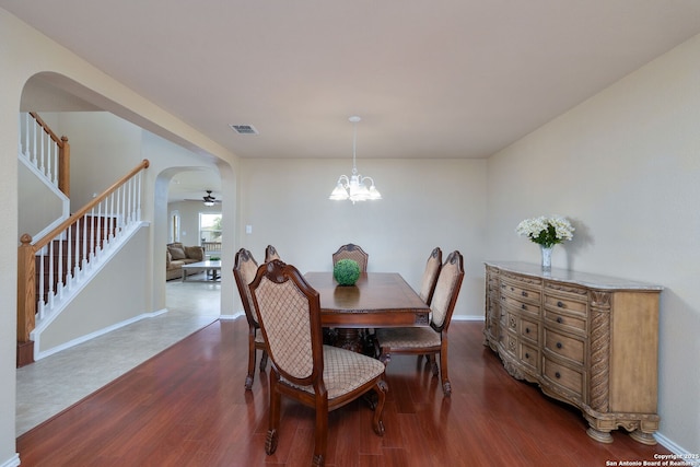 11106 Shetland Hls, San Antonio, TX 78254 - dining area with arched walkways, dark wood finished floors, stairs, a chandelier, and baseboards