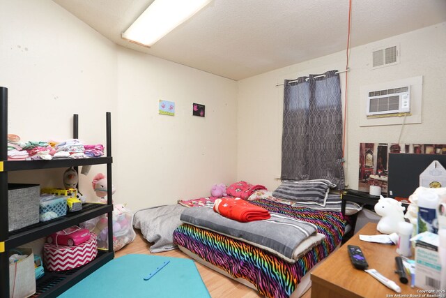 311 W Malone Ave, San Antonio, TX 78214 - bedroom featuring an AC wall unit and wood finished floors
