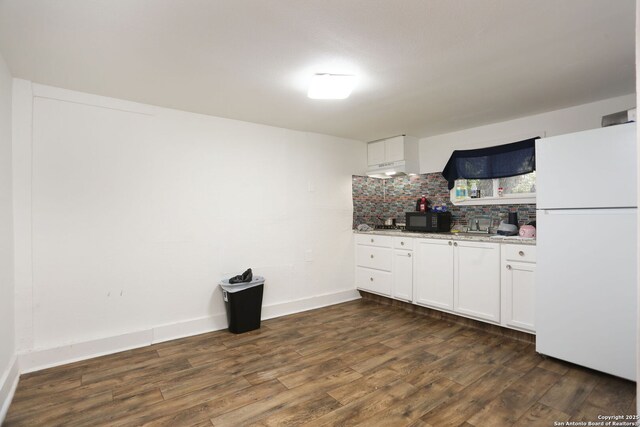 311 W Malone Ave, San Antonio, TX 78214 - kitchen featuring freestanding refrigerator, black microwave, dark wood-style flooring, backsplash, and white cabinetry