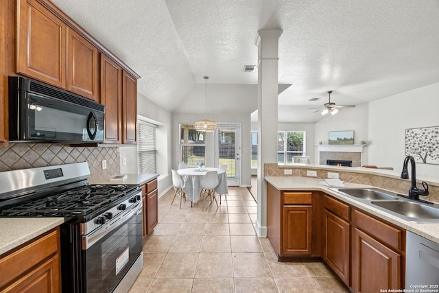 26430 Walden Oak, San Antonio, TX 78260 - kitchen with stainless steel appliances, a sink, decorative backsplash, a ceiling fan, and a tiled fireplace