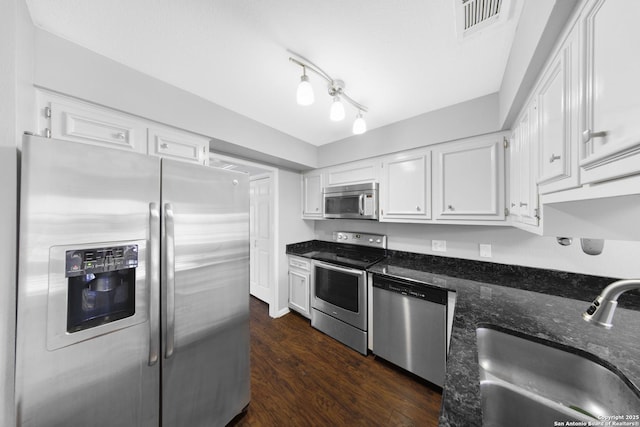 2611 Eisenhauer Unit 104A, San Antonio, TX 78209 - kitchen featuring stainless steel appliances, a sink, white cabinetry, dark stone countertops, and dark wood-style floors