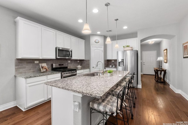 7635 Paraiso Crst, Boerne, TX 78015 - kitchen with stainless steel appliances, a sink, arched walkways, baseboards, and recessed lighting