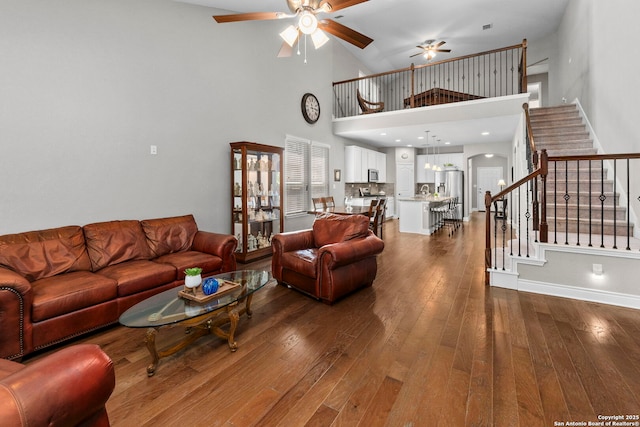 7635 Paraiso Crst, Boerne, TX 78015 - living area featuring ceiling fan, a towering ceiling, dark wood-style floors, stairs, and baseboards