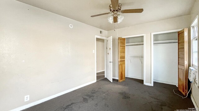 103 Pollydale Ave, San Antonio, TX 78223 - unfurnished bedroom featuring two closets, dark colored carpet, baseboards, and a ceiling fan