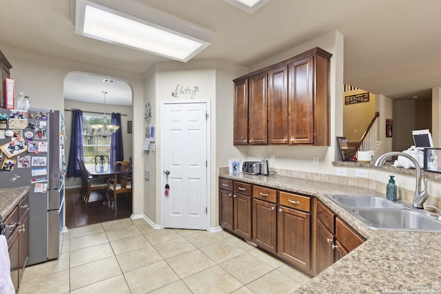 738 Daisy Xing, San Antonio, TX 78245 - kitchen with a sink, freestanding refrigerator, light tile patterned floors, light countertops, and a chandelier