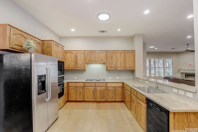 154 Roseheart, San Antonio, TX 78259 - kitchen featuring black appliances, a sink, light wood-style floors, light countertops, and decorative backsplash