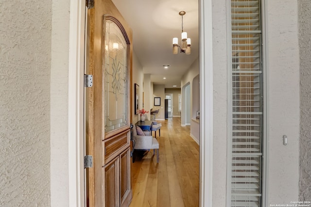 154 Roseheart, San Antonio, TX 78259 - hallway with light wood-style flooring, a chandelier, and baseboards