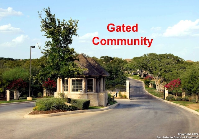 154 Roseheart, San Antonio, TX 78259 - view of asphalt road with curbs, a gate, street lighting, and a gated entry