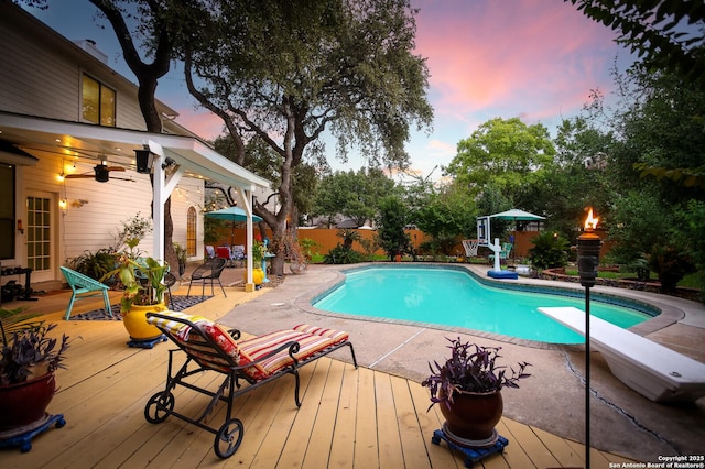 6407 Lost Arbor, San Antonio, TX 78240 - pool at dusk featuring a deck, a diving board, a fenced backyard, a ceiling fan, and a patio area
