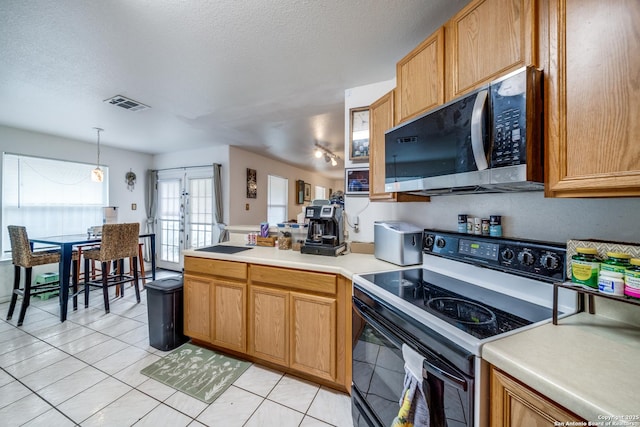 5362 Chestnut Vw, San Antonio, TX 78247 - kitchen featuring black range with electric cooktop, stainless steel microwave, a peninsula, light tile patterned floors, and a textured ceiling