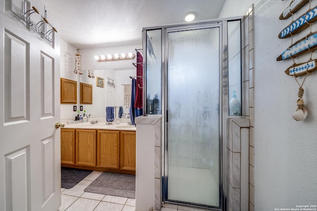 5362 Chestnut Vw, San Antonio, TX 78247 - bathroom featuring a shower stall, tile patterned floors, double vanity, and a textured ceiling