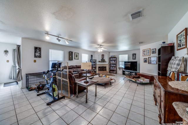 5362 Chestnut Vw, San Antonio, TX 78247 - living area with light tile patterned flooring, ceiling fan, a fireplace, and a textured ceiling