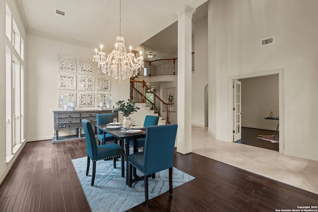 1238 Via Belcanto, San Antonio, TX 78260 - dining room with a high ceiling, stairs, baseboards, wood finished floors, and a chandelier