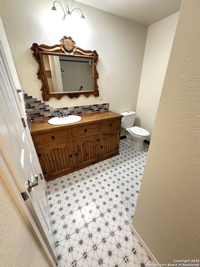 207 Freiling, San Antonio, TX 78213 - bathroom featuring tile patterned floors, a textured wall, toilet, vanity, and tasteful backsplash