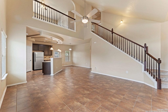 8903 Derby Dan, Converse, TX 78109 - unfurnished living room featuring ceiling fan, baseboards, stairway, and a towering ceiling