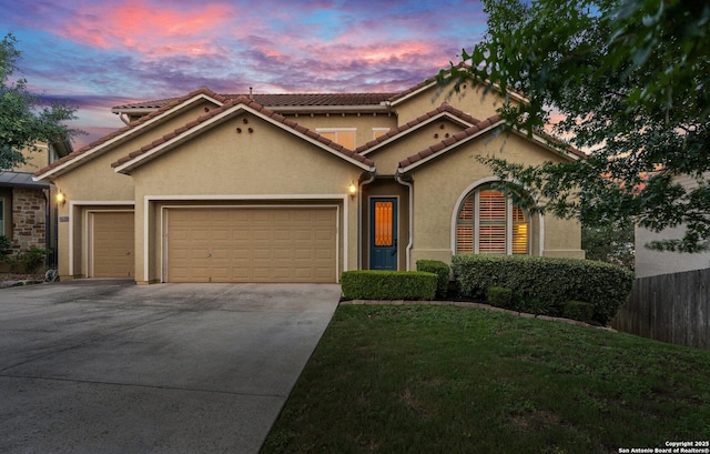 17906 Via Del Arbol, San Antonio, TX 78257 - mediterranean / spanish-style house with an attached garage, stucco siding, driveway, and a tiled roof