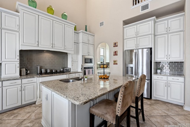 17906 Via Del Arbol, San Antonio, TX 78257 - kitchen featuring appliances with stainless steel finishes, a towering ceiling, tasteful backsplash, arched walkways, and a sink