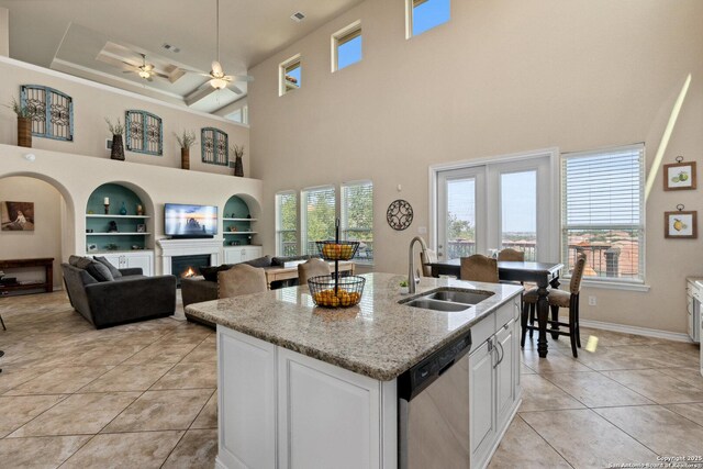 17906 Via Del Arbol, San Antonio, TX 78257 - kitchen featuring a lit fireplace, dishwasher, a sink, a ceiling fan, and built in shelves