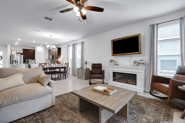 5219 Wolf Bane, San Antonio, TX 78261 - living area featuring a glass covered fireplace, recessed lighting, a ceiling fan, a chandelier, and light tile patterned flooring