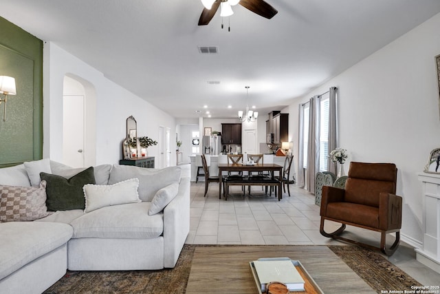 5219 Wolf Bane, San Antonio, TX 78261 - living room with a ceiling fan, arched walkways, light tile patterned floors, and a chandelier