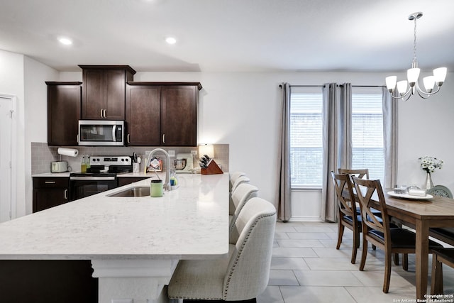 5219 Wolf Bane, San Antonio, TX 78261 - kitchen featuring stainless steel appliances, light countertops, a sink, a chandelier, and dark brown cabinetry