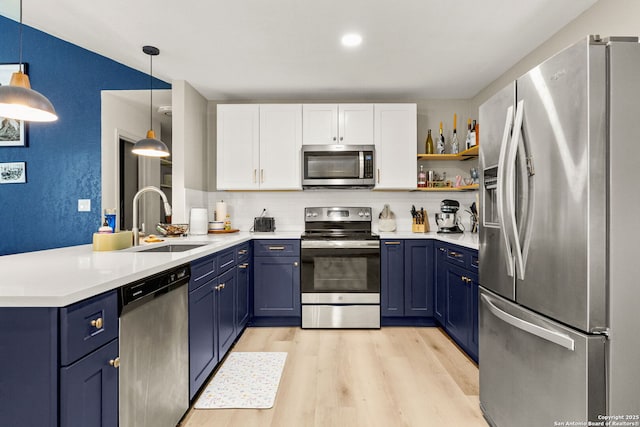 922 Sundance, New Braunfels, TX 78130 - kitchen with appliances with stainless steel finishes, blue cabinetry, a sink, and a peninsula