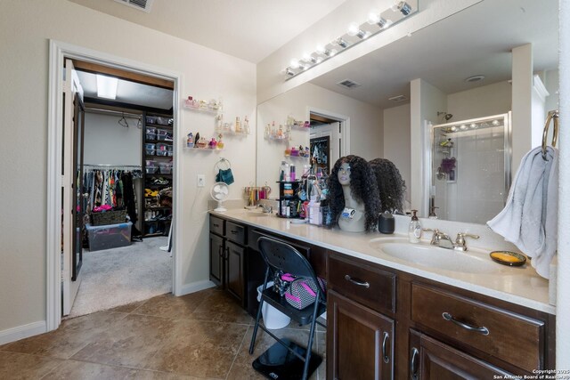 4310 Gambels Quail, Converse, TX 78109 - bathroom featuring a stall shower, double vanity, a walk in closet, and baseboards