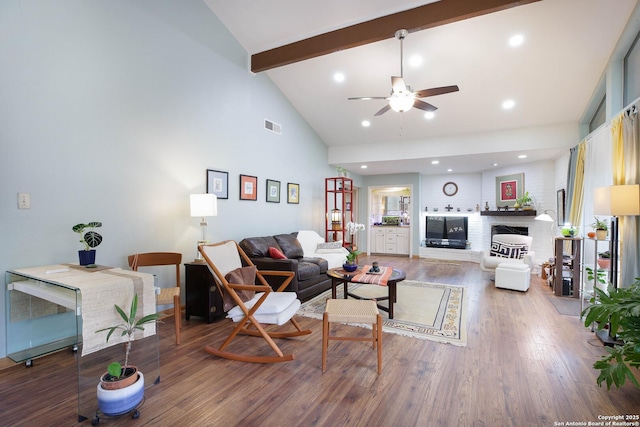11700 Mission Trce, San Antonio, TX 78230 - living room with beamed ceiling, high vaulted ceiling, wood finished floors, a ceiling fan, and a brick fireplace